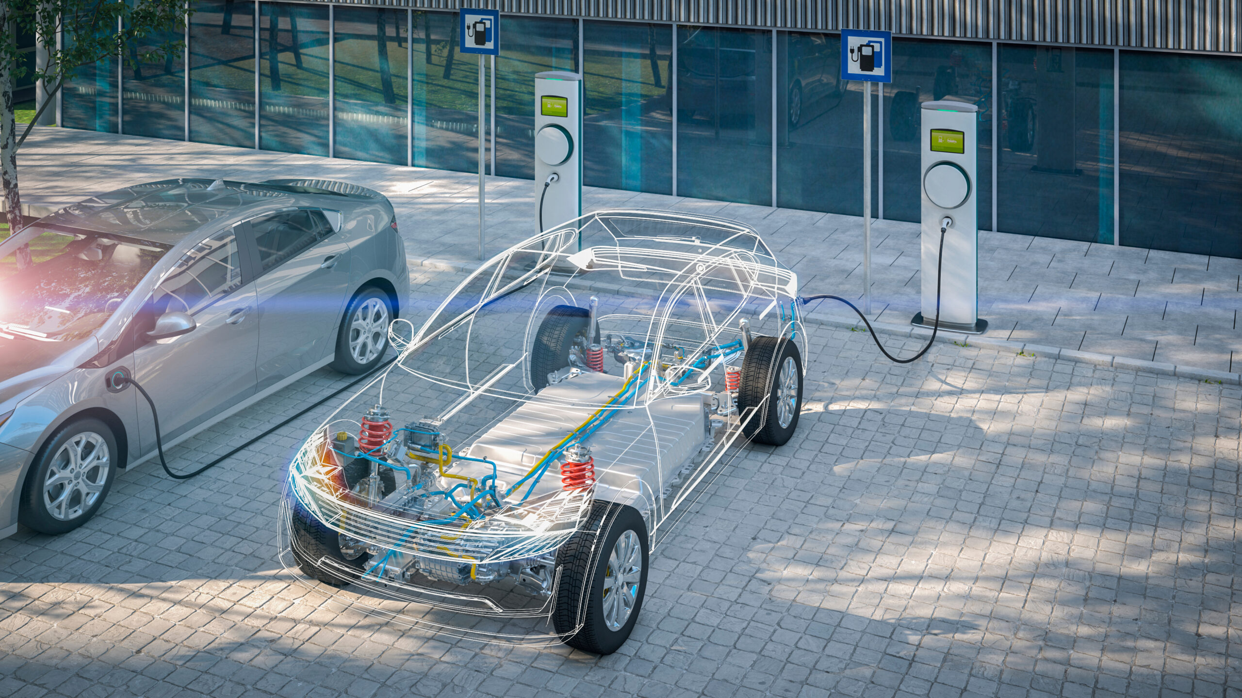 A realistic scene of electric cars charging at a station. One vehicle is fully visible, while the other has a semi-transparent overlay showing internal components like the battery and electrical wiring. The backdrop features a modern building and a tree casting shadows. - CSA Catapult