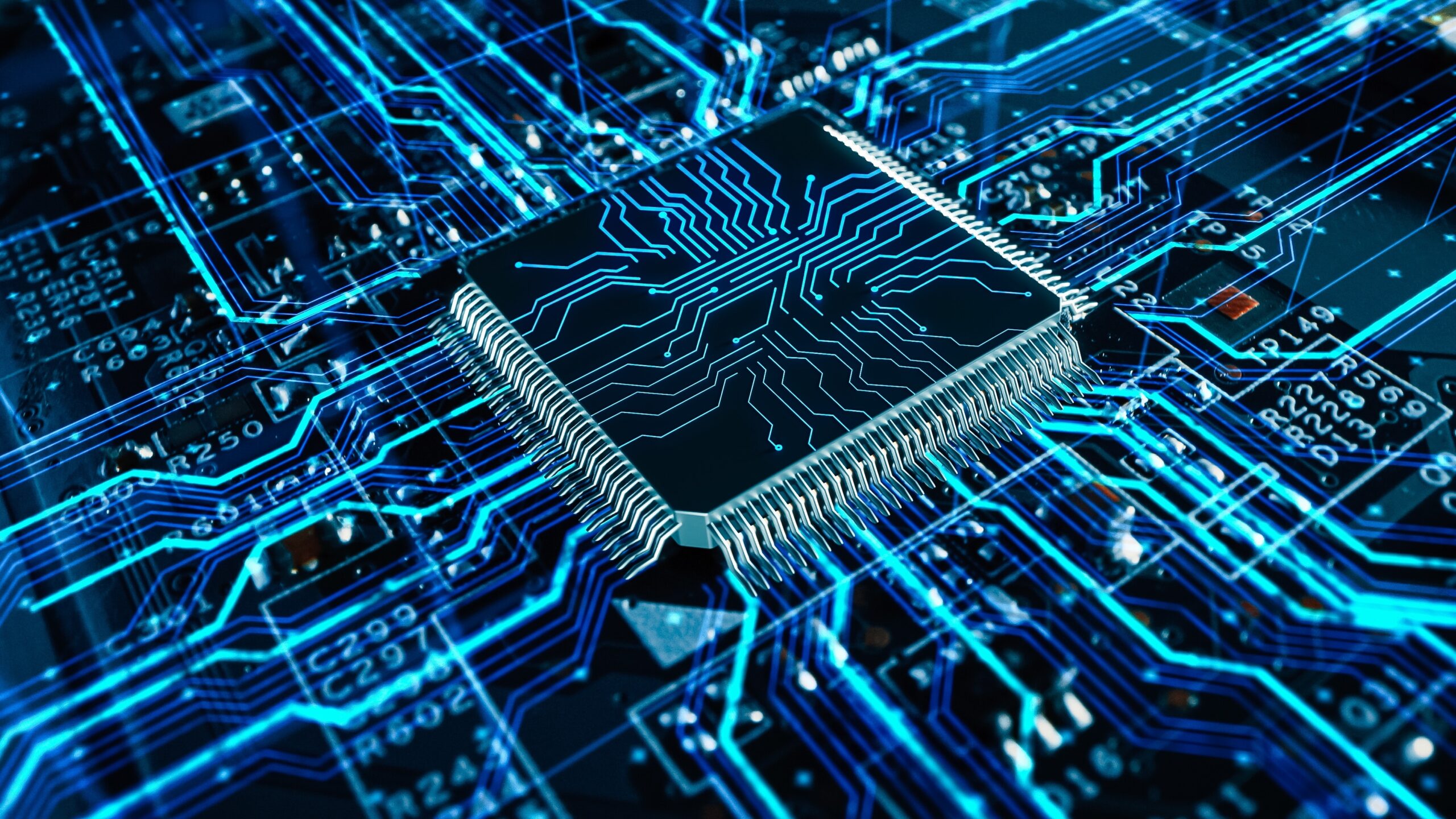 A close-up view of a microchip on a circuit board. The microchip is centrally positioned and connected to a network of glowing blue lines representing electronic pathways on the dark blue-toned circuit board. - CSA Catapult