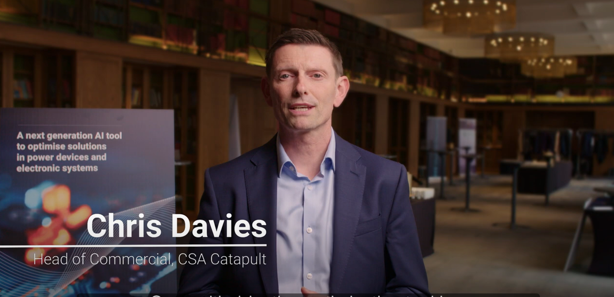 Head of Commercial Chris Davies stands in a modern conference room with a sign about optimizing solutions in electronic systems. - CSA Catapult