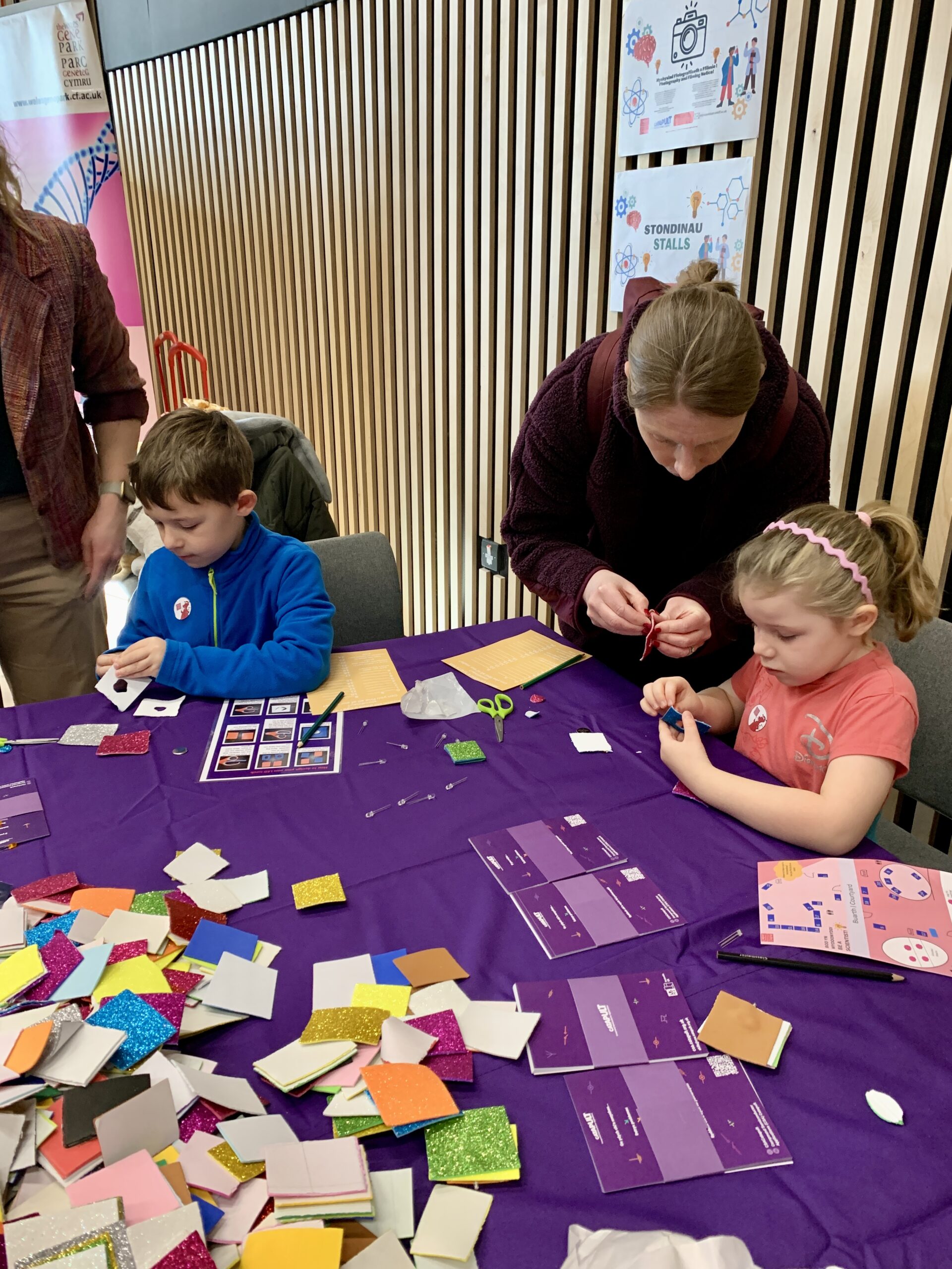 Children and an adult are crafting at a table, honing their skills like those nurtured at the CSA Catapult Skills Academy. - CSA Catapult