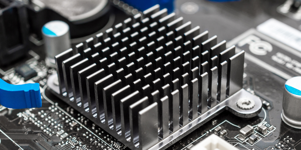 Close-up of a GaN-enhanced heatsink on a computer motherboard with silver fins and blue components nearby. - CSA Catapult