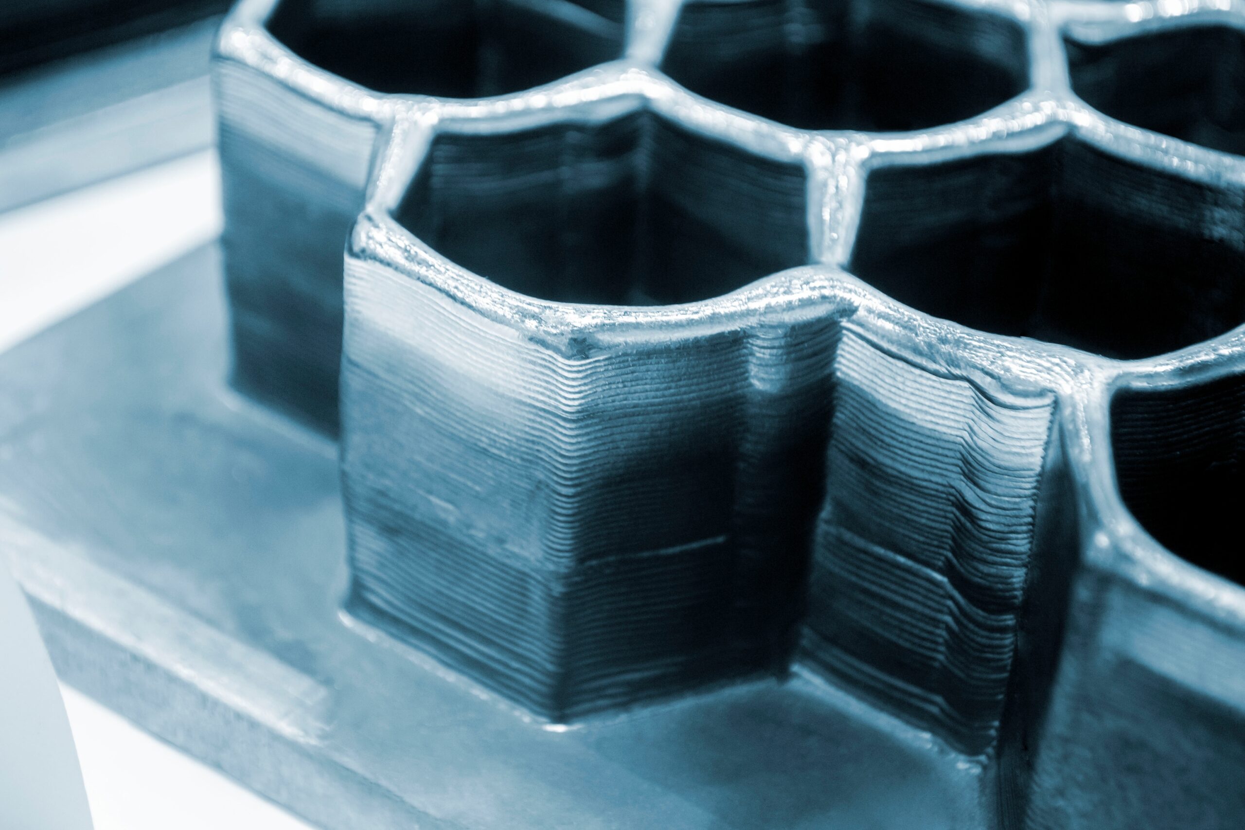 Close-up of a metallic, hexagonal GaN 3D-printed structure with layered texture and a glossy finish. - CSA Catapult