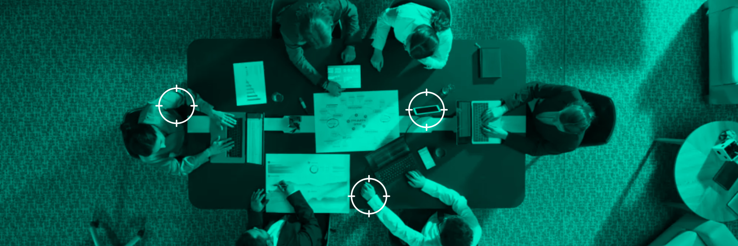 Overhead view of six people working at a table with laptops, papers, charts, and GPS-marked target circles. - CSA Catapult
