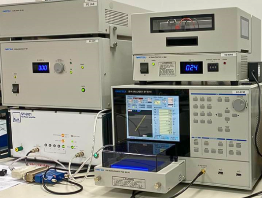 Laboratory equipment, including a BH Loop Analyser with digital displays and cables, on a workbench. - CSA Catapult