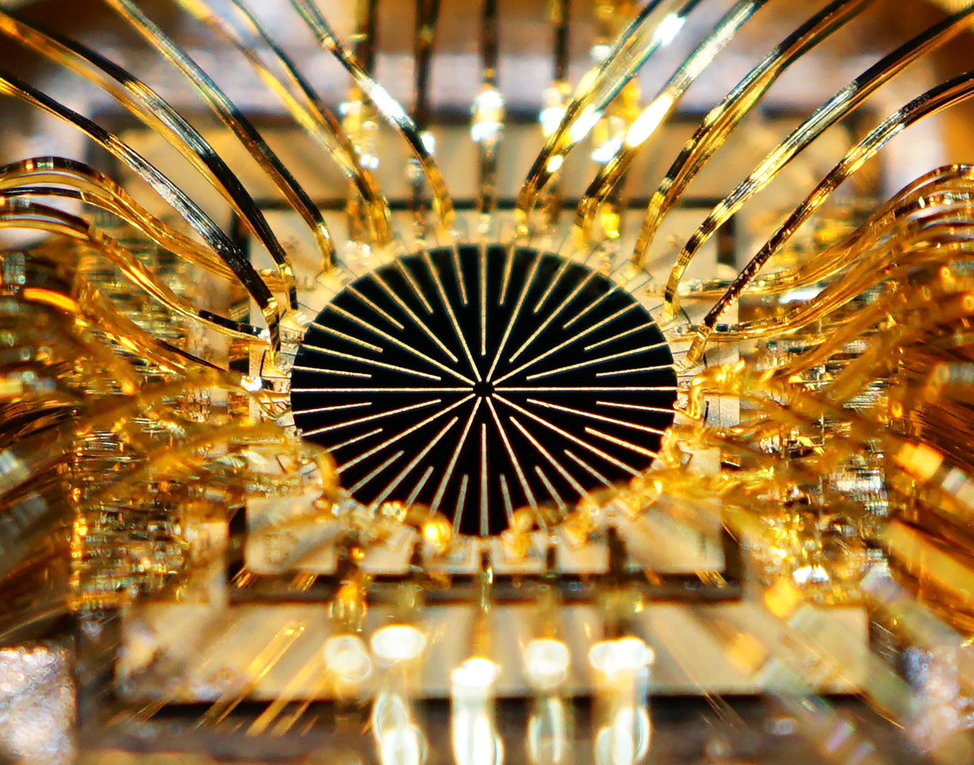 Close-up of a circular microchip with gold connectors, highlighting WiPDA Power Electronics in a symmetrical pattern. - CSA Catapult