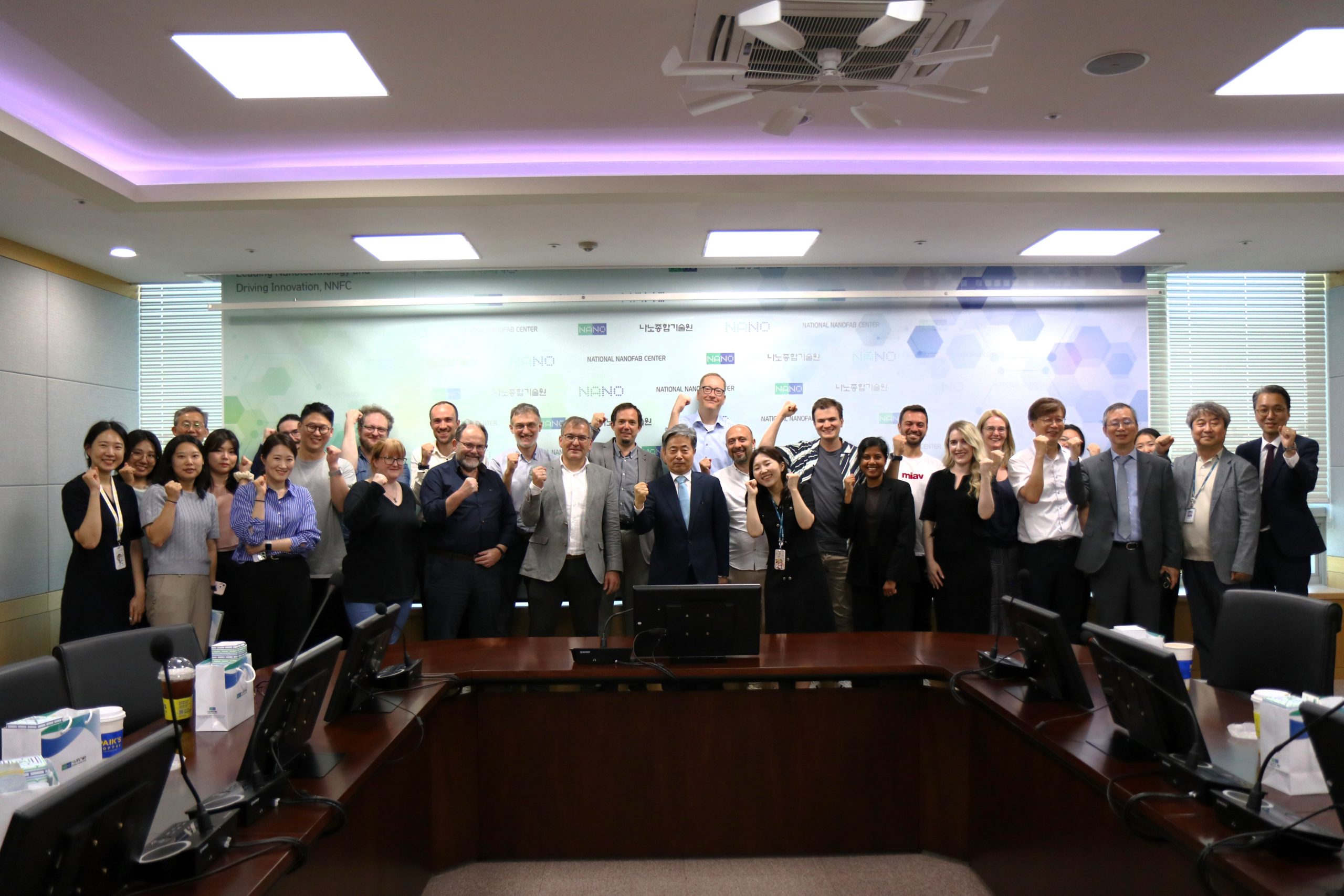 A large group at the International Semiconductor Researchers Forum pose and smile in a conference room, many giving thumbs-up gestures. - CSA Catapult