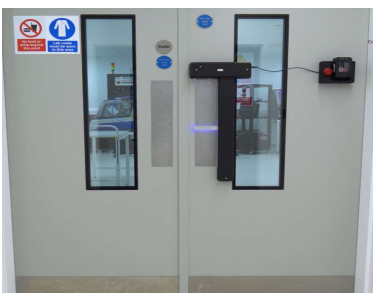 Double doors with windows, push signs, and safety notices, leading to a medical or laboratory area. - CSA Catapult