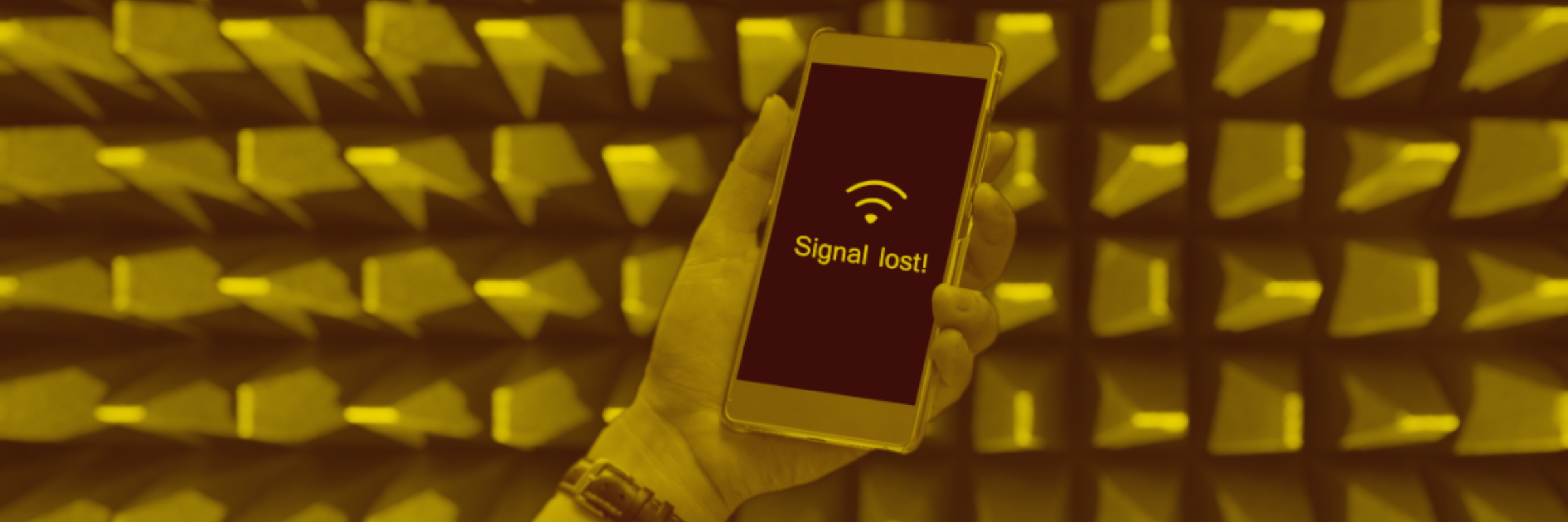 A hand holds a phone—one of many personal electronic devices—displaying 