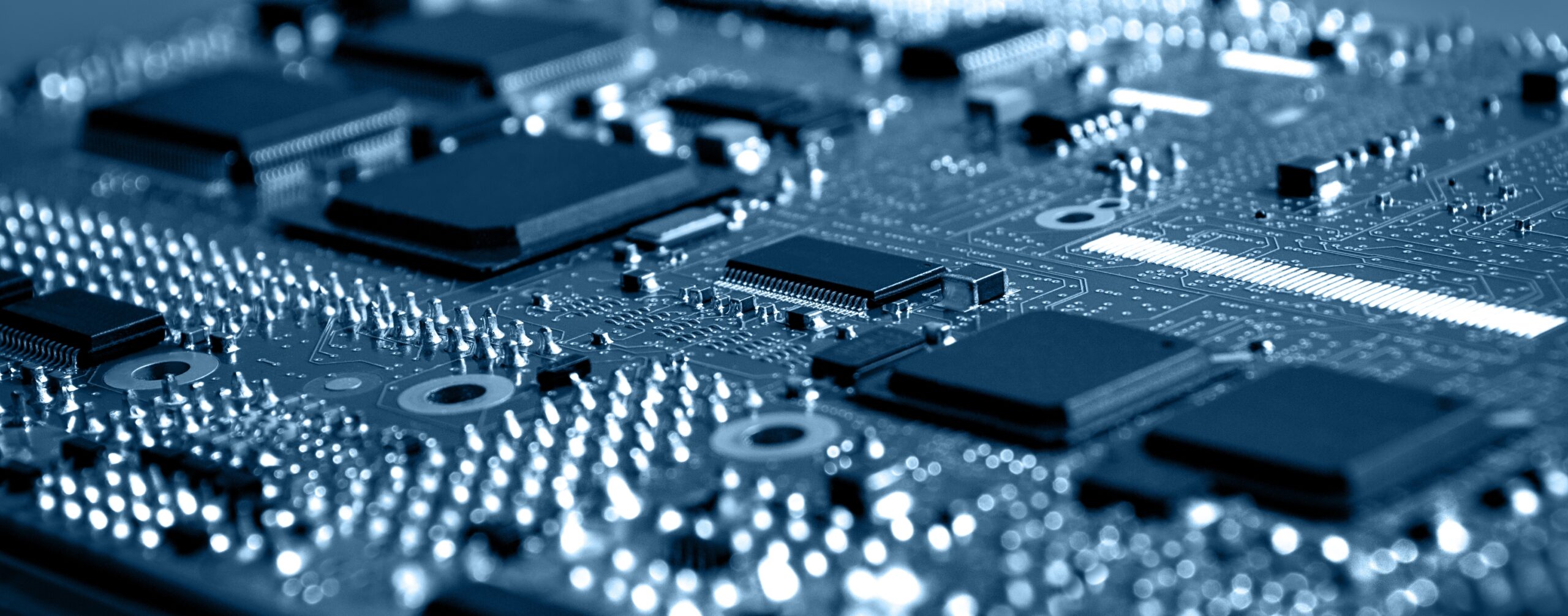 Close-up view of a blue-toned electronic circuit board highlighting microchips and security-focused components. - CSA Catapult